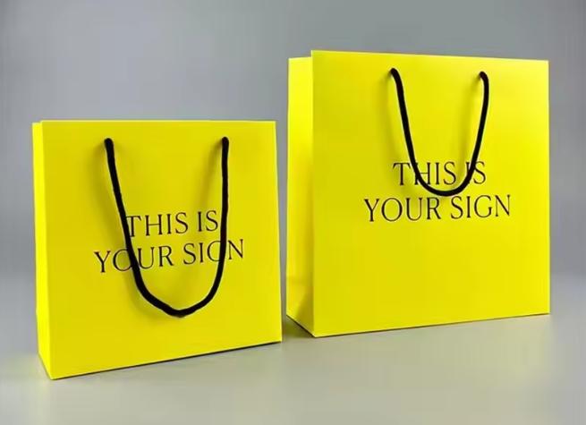 Sturdy, structured paper tote bag with reinforced punched holes and black cord handles; customizable shopping or gift bag